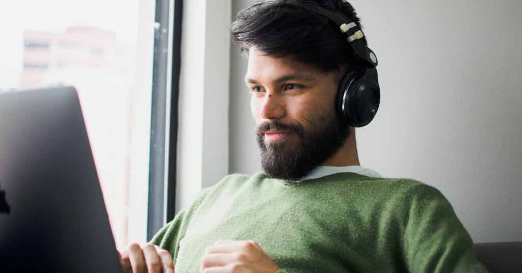 Image of a satisfied man sitting in front of laptop