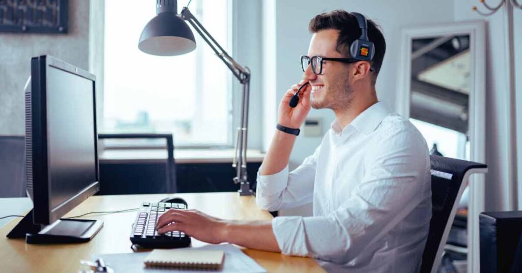 Man in front of computer providing customer support