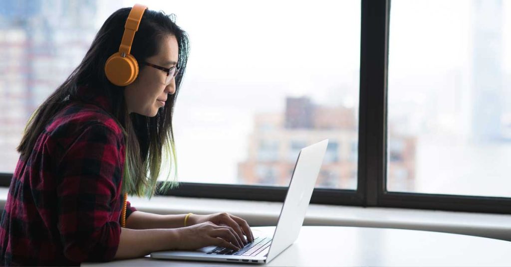 Person transcribing audio on laptop